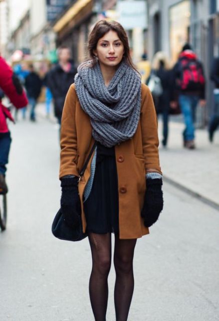 Office-worthy winter outfit with black dress, black tights, brown coat and mittens