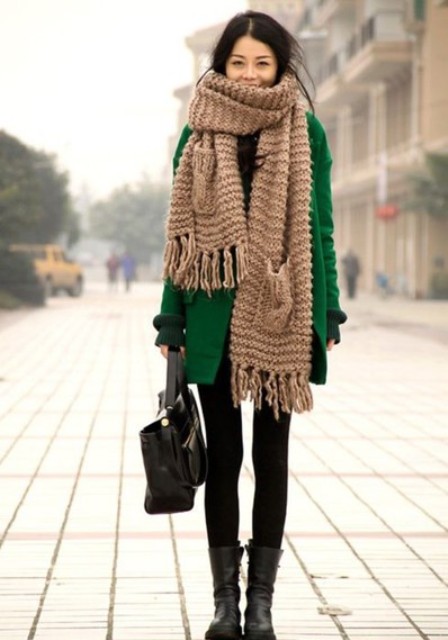 With green coat, dress, mid calf boots and leather bag