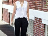 a casual look with a white sleeveless shirt, black side-striped pants, silver shoes, a statement necklace and a clutch