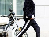 a chic outfit with black side-striped pants, black heels, a black faux fur coat for a statement