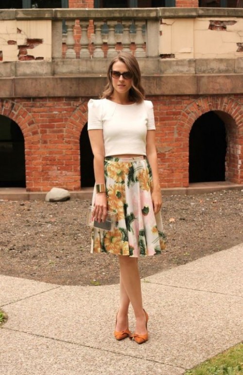 a chic work look with a white crop top, a midi floral A-line skirt, orange shoes and a clear clutch