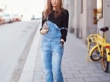 a black top, a blue denim dungaree and black slipons for a comfortable spring look