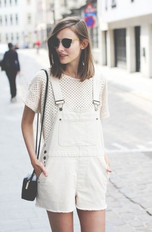 a white poerforated top, a whiet denim dungaree with shorts, a black crossbody for an effortless summer look