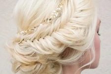 a cool fishtail braid updo with some locks down and a hair vine for a girlish look