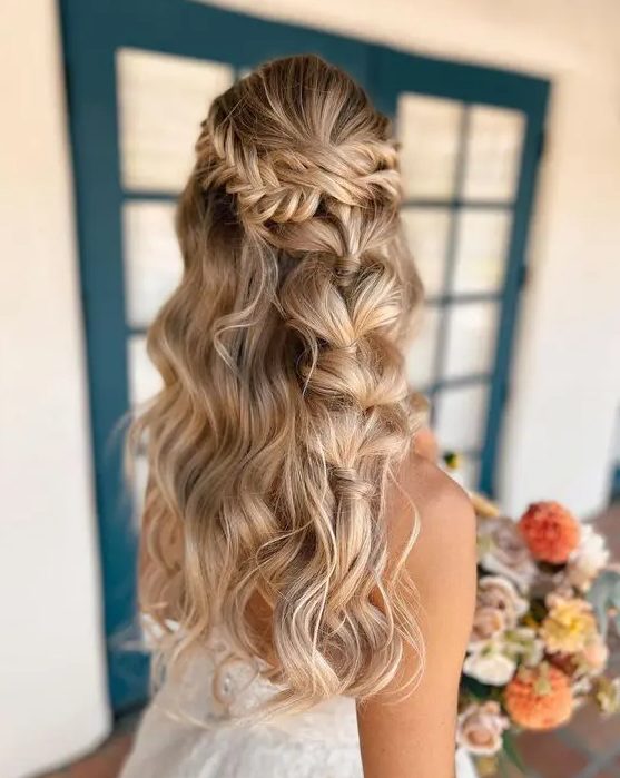 a creative boho wedding half updo with a fishtail braid halo and a bubble braid and waves down is amazing