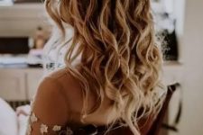 a delicate and lovely boho half updo with a fishtail braid halo and waves down is ideal for a boho bride