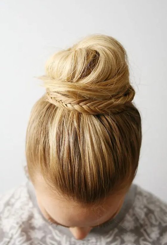 a fishtail braid embellished top knot with a sleek top will be a cool and catchy idea for a boho or rustic wedding