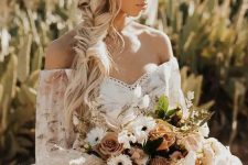 a gorgeous boho bridal hairstyle with a braided halo and a loose fishtail side braid plus a chamomile headband