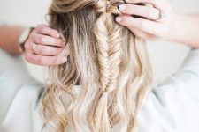 a pretty boho half updo with a bump on top, a fishtail braid and waves down is a cool solution for Christmas