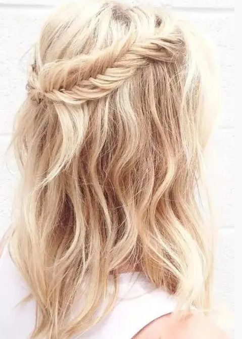 a wavy and textural half updo with a fishtail braid to frame it is a relaxed and cute option