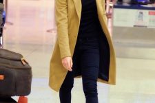 an elegant casual outfit with a black turtleneck, navy pants, black loafers and a mustard coat for a colorful accent