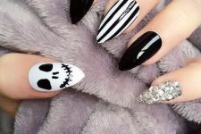 a black and white manicure with stripes, a skull and an embellished nail for Halloween