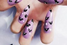 a purple manicure with white stars and small black bats for Halloween will add a bit of color