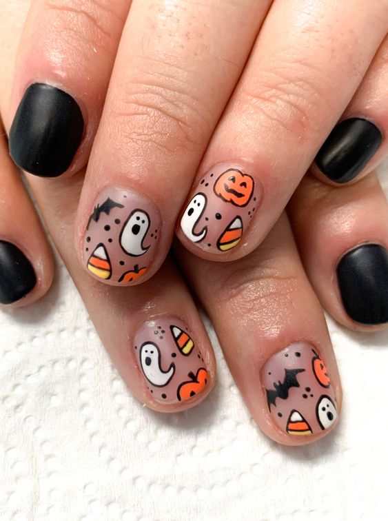 matte lack and nude nails with candy corns, ghosts and bats are all cute and super chic for Halloween