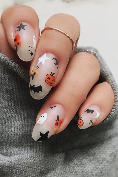 matte nude nails with ghosts, bats, moons, stars and pumpkins are amazing and super fun