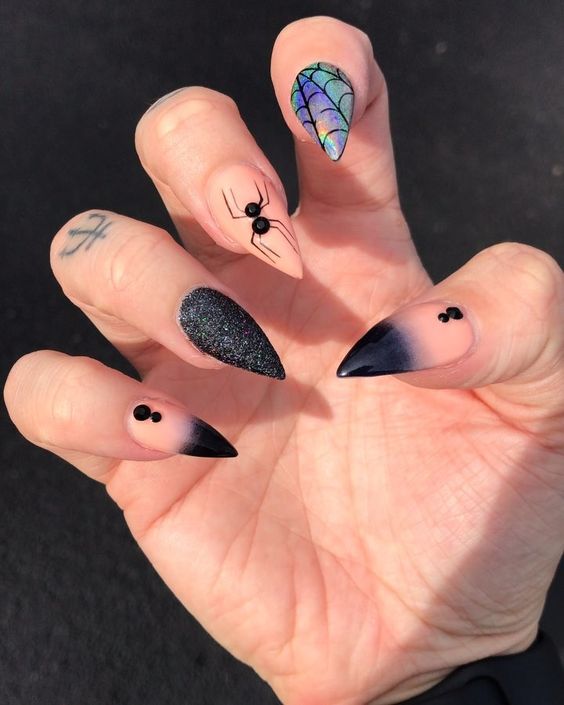 nude, black glitter and iridescent nails with rhinestones, spiders and spiderwebs are bold and cool