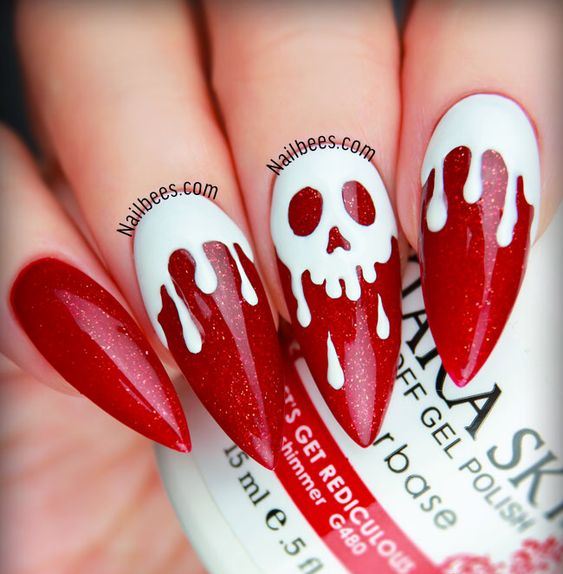 sharp red glitter nails with white marks and a skull in the center is a very bold and cool idea for Halloween