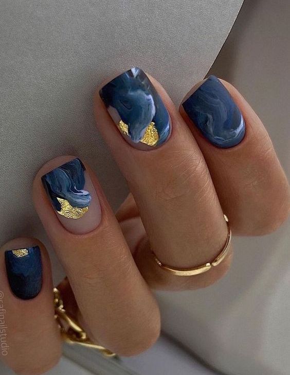 a bold NYE manicure with navy and blue swirls, gold foil and matte surfaces is amazing