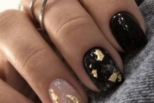 a cool and shiny NYE manicure with nude and black nails and gold foil is adorable for parties