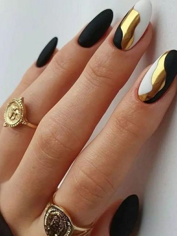 a fantastic black, gold and white manicure with curves is a lovely idea for NYE parties