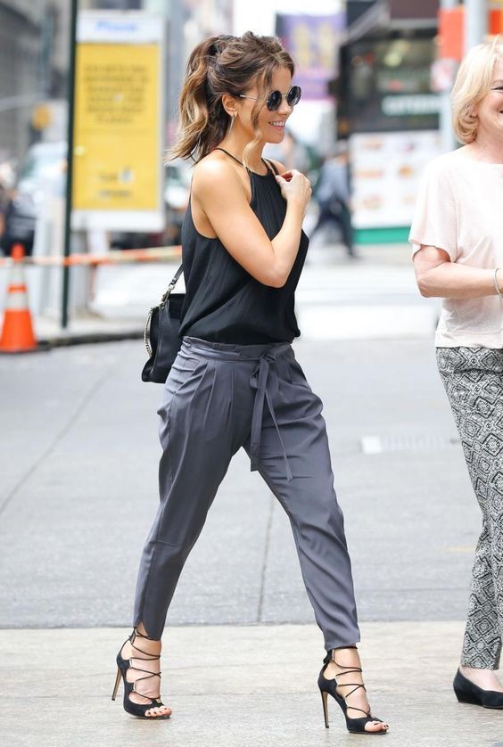 a halter neckline top, black strappy shoes and grey pants plus a black bag for a sexy summer work look