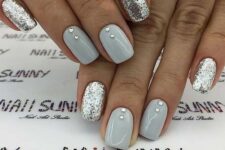 a holiday or wedding manicure with shiny grey nails accented with rhinestones and silver glitter nails