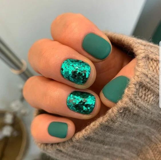 a matte emerald manicure with two accent sequin nails is a chic and bold idea for Christmas