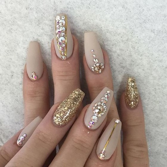 A matte nude nail art with gold glitter, gold stripes and rhinestones is a fantastic and jaw dropping idea for NYE parties
