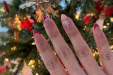 a nude and red Christmas manicure with gift ribbons and snowflakes is a lovely idea for the holidays