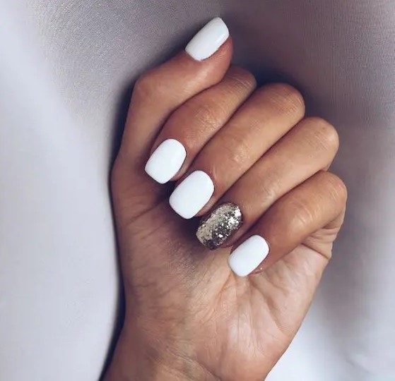 a white manicure with a gold glitter accent nail is a timeless and stylish idea to rock for a NYE party