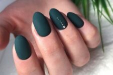 matte black nails with an accent nail with shiny dots are bold and chic and will match many Christmas party looks