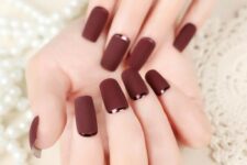 matte burgundy nails with dark copper crescent moon accents are a refined and chic idea for Christmas parties