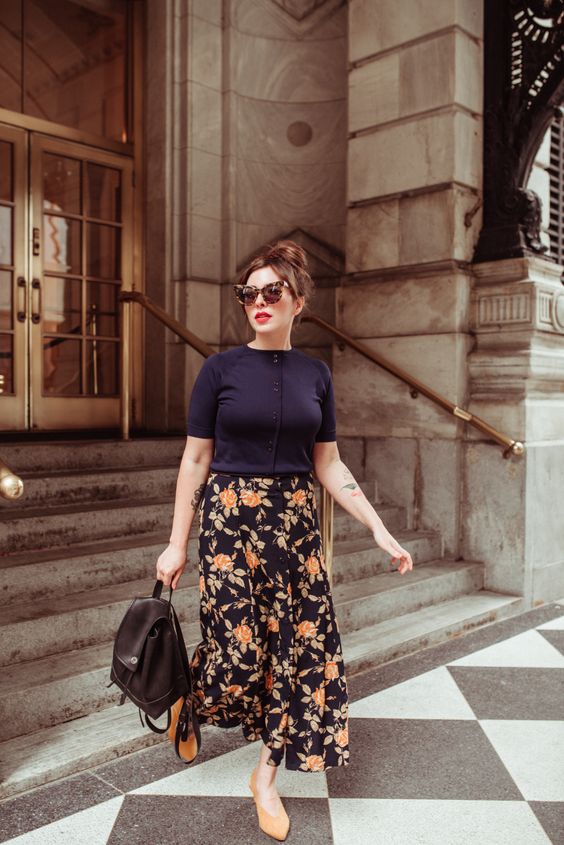a fall work look with a black button up, a dark floral midi skirt, a black backpack and orange shoes