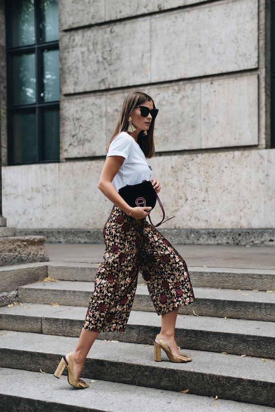a statement summer work look with a white tee, dark floral culottes, gold shoes and statement earrings