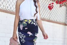 a summer work outfit with a white halter neckline bow top, a dark floral midi skirt, a pink bag
