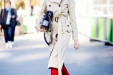 a neutral oversized trench with black buttons and a hood is balanced with red boots that add color