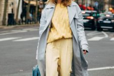 a powder blue midi trench paired wiht a sunny yellow look and a turquoise bag for a springy feel