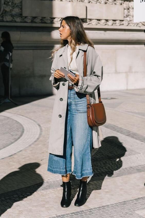 an oversized grey midi trench, flare jeans, black boots and a brown bag for a retro feel in your look
