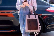 Gwen Stefani wearing a grey sweatshirt, a blue denim overall and yellow shoes plus a large tote