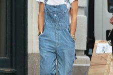 Rita Ora wearing a white tee, a blue denim dungaree, white sneakers and statement earrings just wows