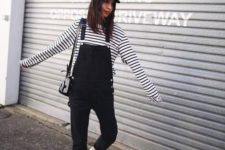 a striped black and white top, a black dungaree, white sneakers and a black crossbody for a monochromatic spring look