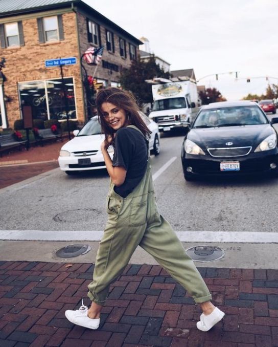an oversized black tee, an oversized green dungaree, white sneakers for a simple and effortless spring look