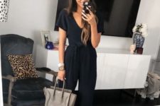 a black jumpsuit with a sasj, grey suede heels and a grey bag plus stacked bracelets