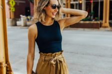 a black sleeveless top, mustard-colored paperbag pants and a leopard clutch for hot summer days