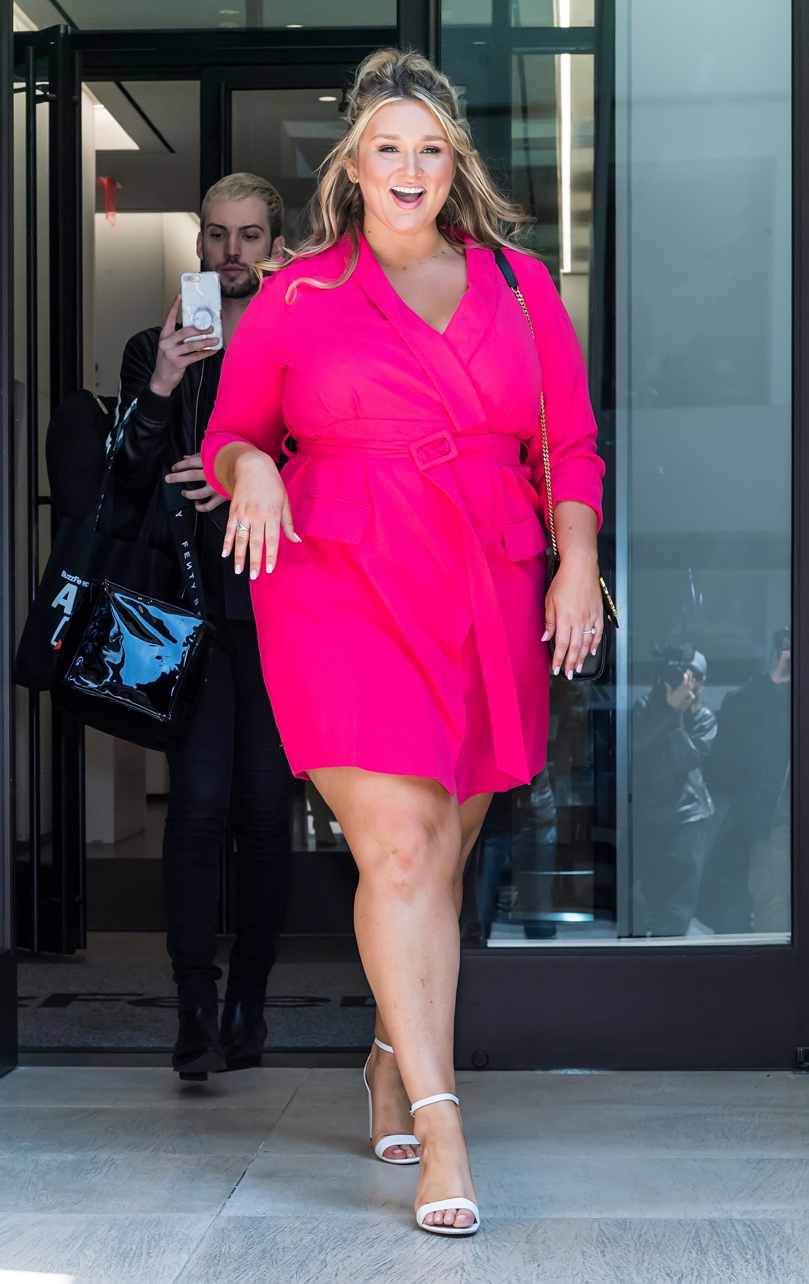 a hot pink wrap mini dress with long sleeves, white shoes and a black bag for a hot summer day
