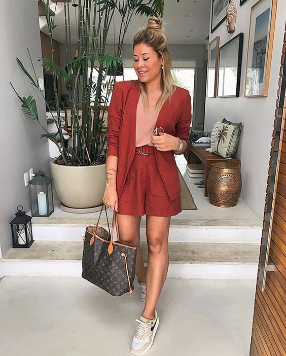 a red suit with shorts, a blush top, tan trainers, a brown tote for a bold summer work look