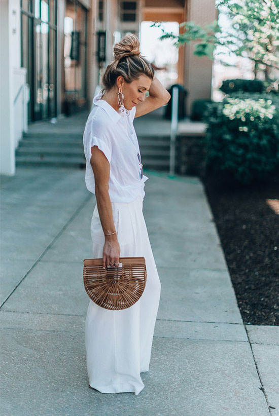 a white oversized shirt, creamy palazzo pants, statement earrings and a wooden semi-circle bag