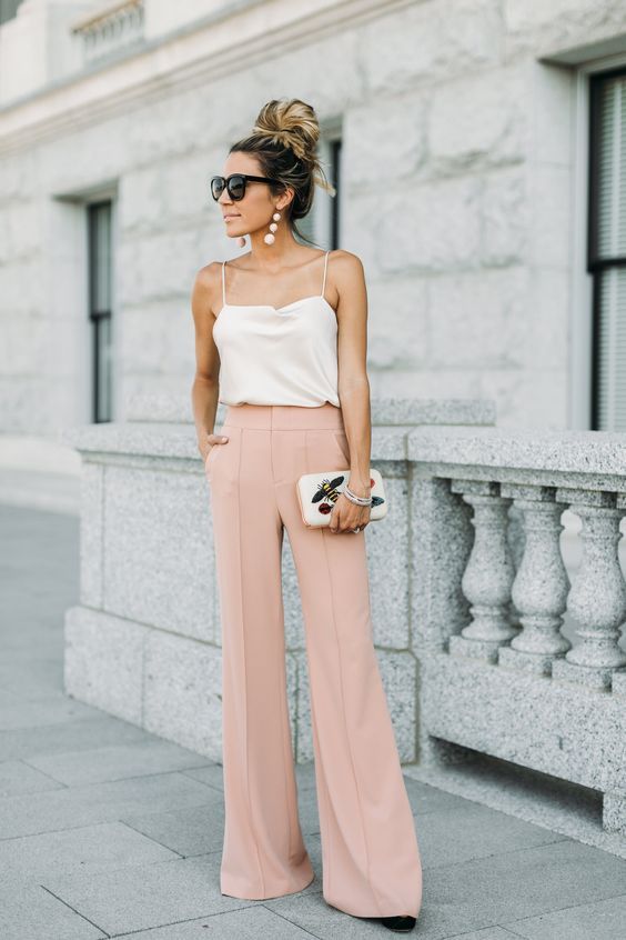 a white spaghetti strap top, blush pants, a white whimsical clutch and statement earrings
