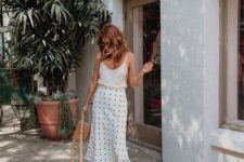 a white top, a polka dot fit and flare midi, white square toe shoes and a brown bag