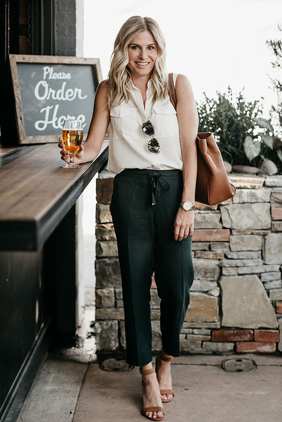 an off-white sleeveless shirt, black pants, rust-colored shoes and a brown leather tote
